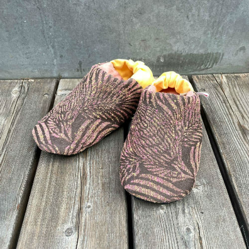 A black and white sketch of two pairs of slippers, low and bootie styles.