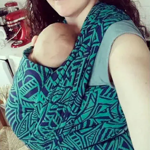 Élodie a porté ses bébés dans son écharpe de portage bleue et verte.