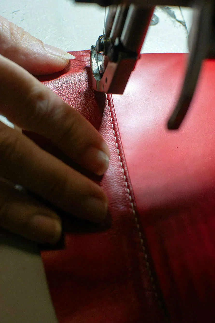 Piqûre d’un sac en cuir rouge à la machine