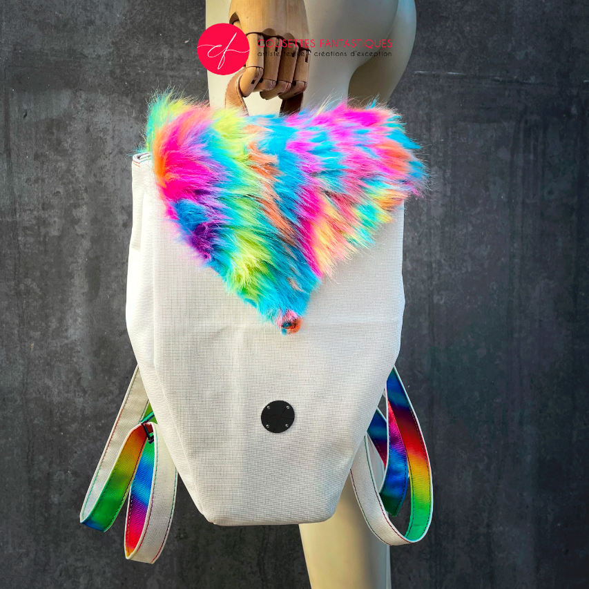 A backpack made from white faux leather and rainbow faux fur.