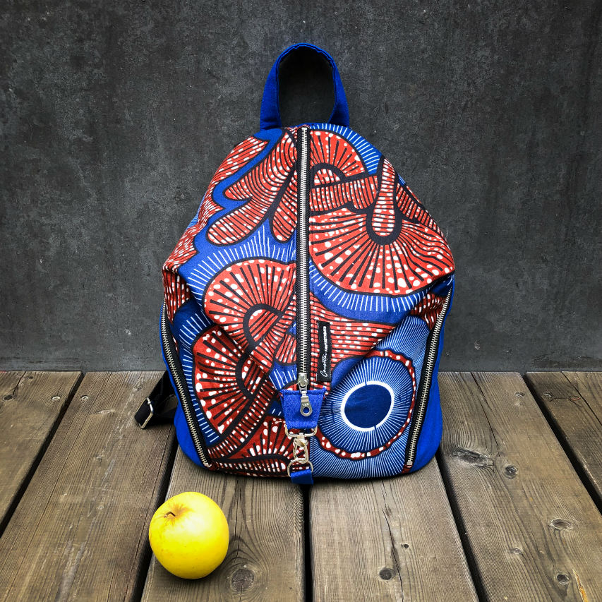 A backpack sewn with royal blue fabric and wax fabric in shades of blue, brown-red, black, and white.