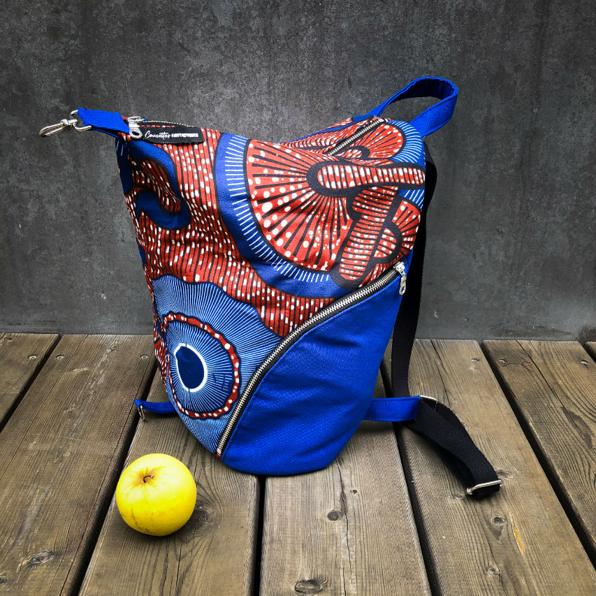A backpack sewn with royal blue fabric and wax fabric in shades of blue, brown-red, black, and white.