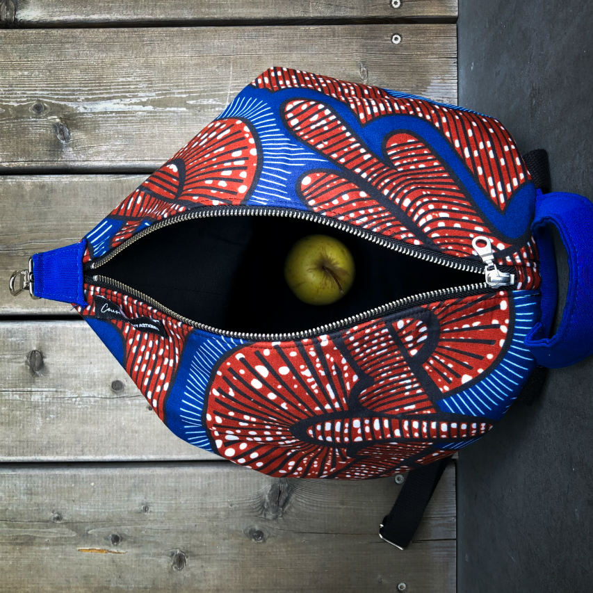 A backpack sewn with royal blue fabric and wax fabric in shades of blue, brown-red, black, and white.