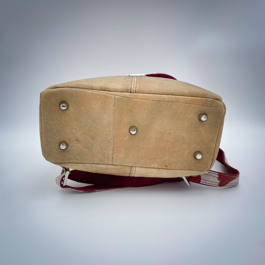 A backpack made from camel colored leather and a red Ginkgo Biloba leaves patterned polycotton canvas.