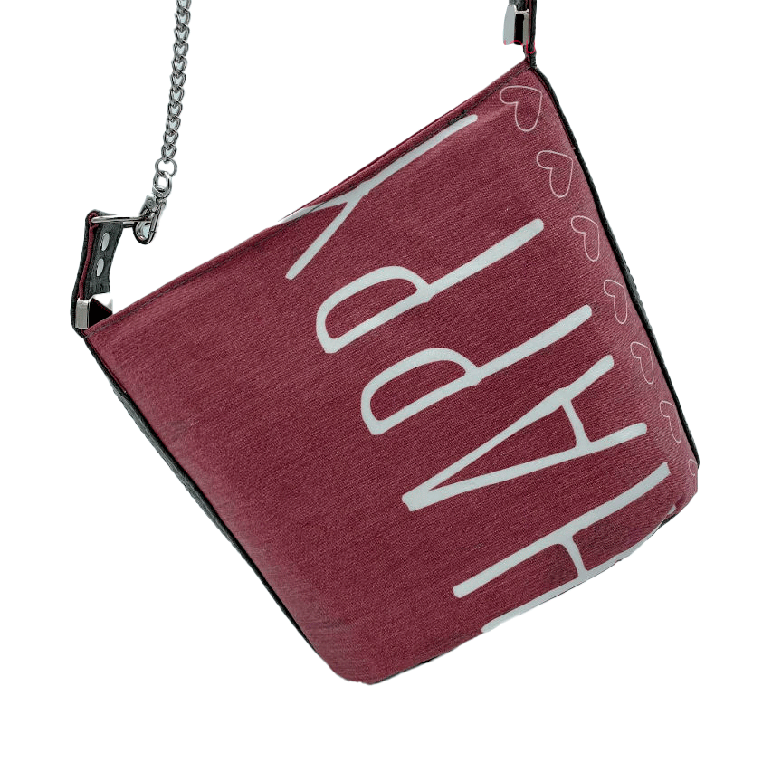 A small “bucket” bag made with delicate pink canvas featuring the word “Happy” and gray ostrich-patterned faux leather.