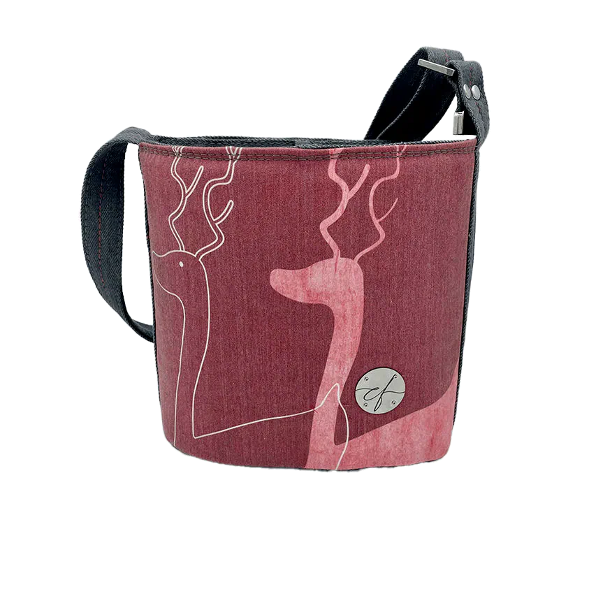 A small “bucket” bag made with delicate pink canvas featuring two white deer silhouettes and gray high-fashion denim.