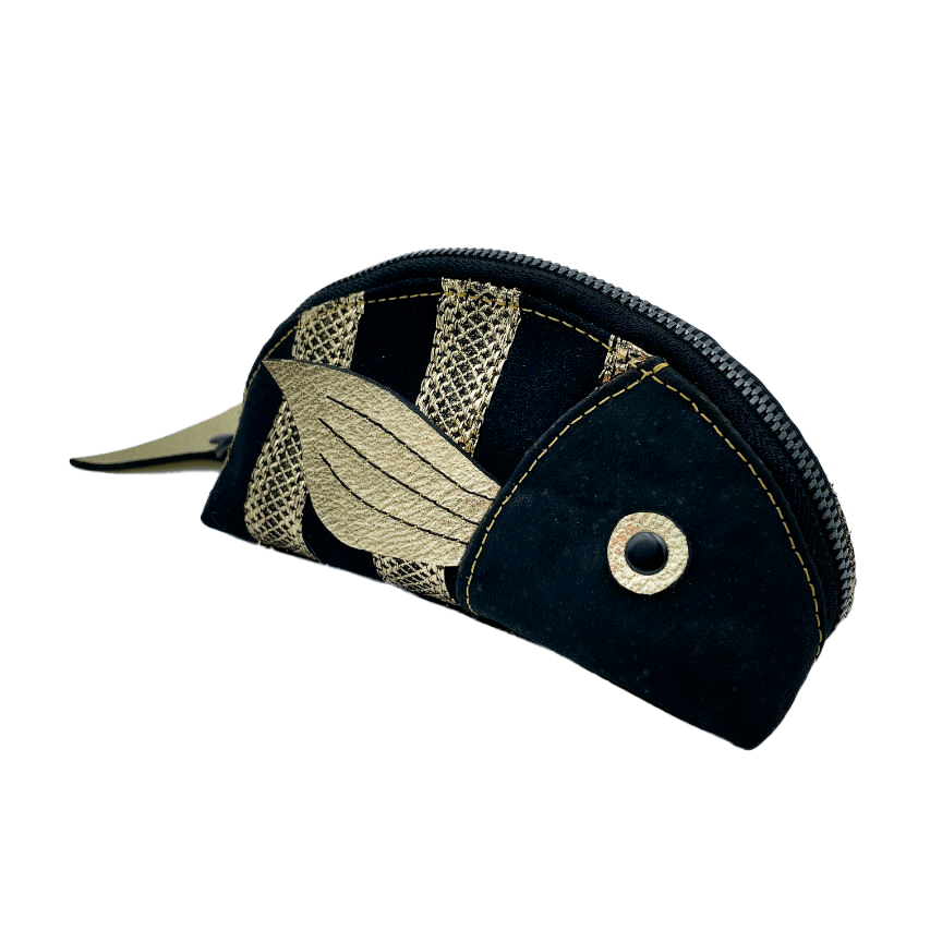 A zippered pouch sewn with black cork, black voile with golden stripes, and golden metallic leather.