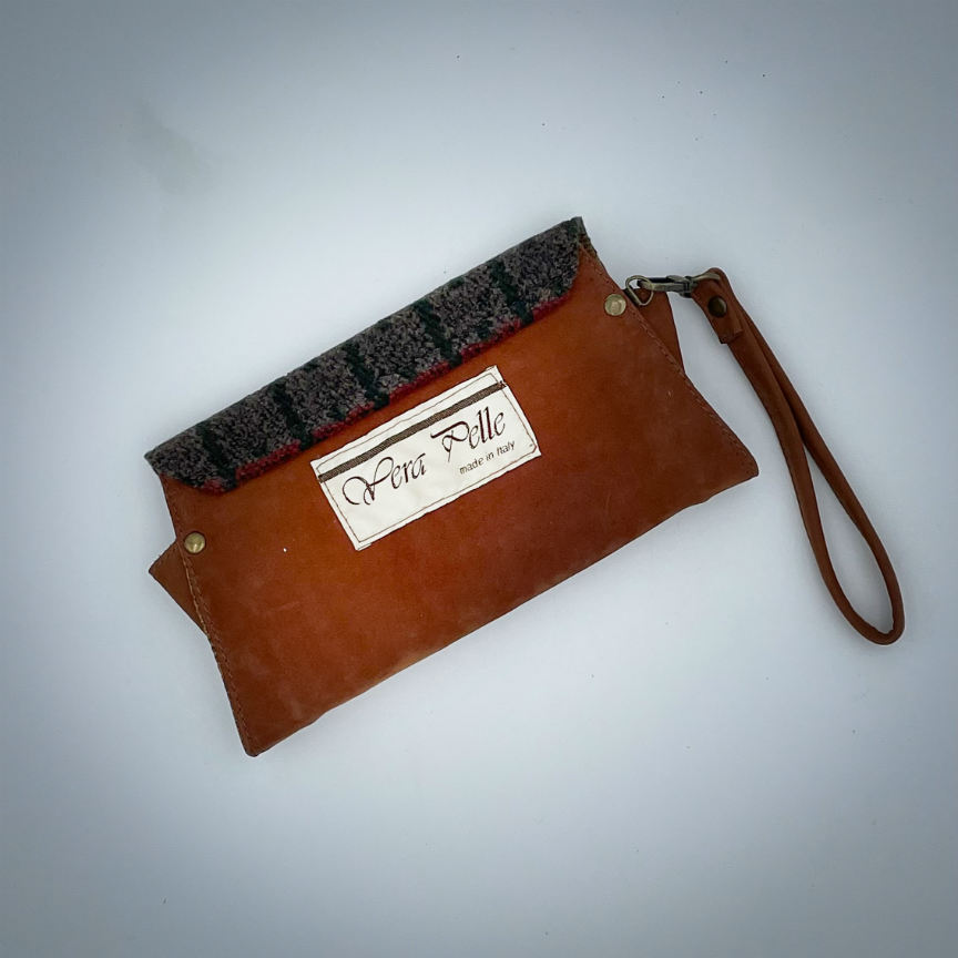 A wallet made from chestnut faux suede and geometric-patterned wool fabric, with a viscose lining featuring a geometric print.