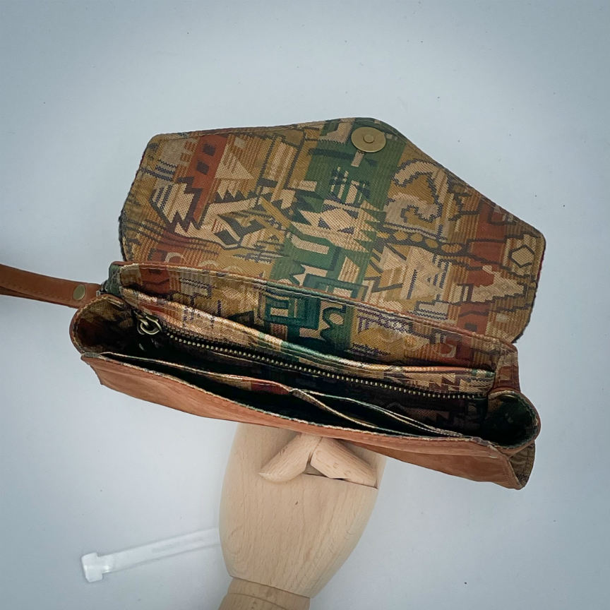 A wallet made from chestnut faux suede and geometric-patterned wool fabric, with a viscose lining featuring a geometric print.