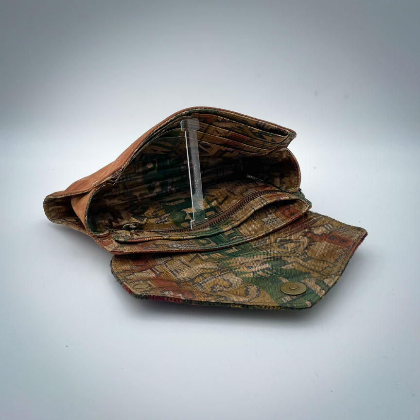 A wallet made from chestnut faux suede and geometric-patterned wool fabric, with a viscose lining featuring a geometric print.