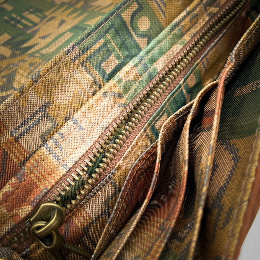 A wallet made from chestnut faux suede and geometric-patterned wool fabric, with a viscose lining featuring a geometric print.