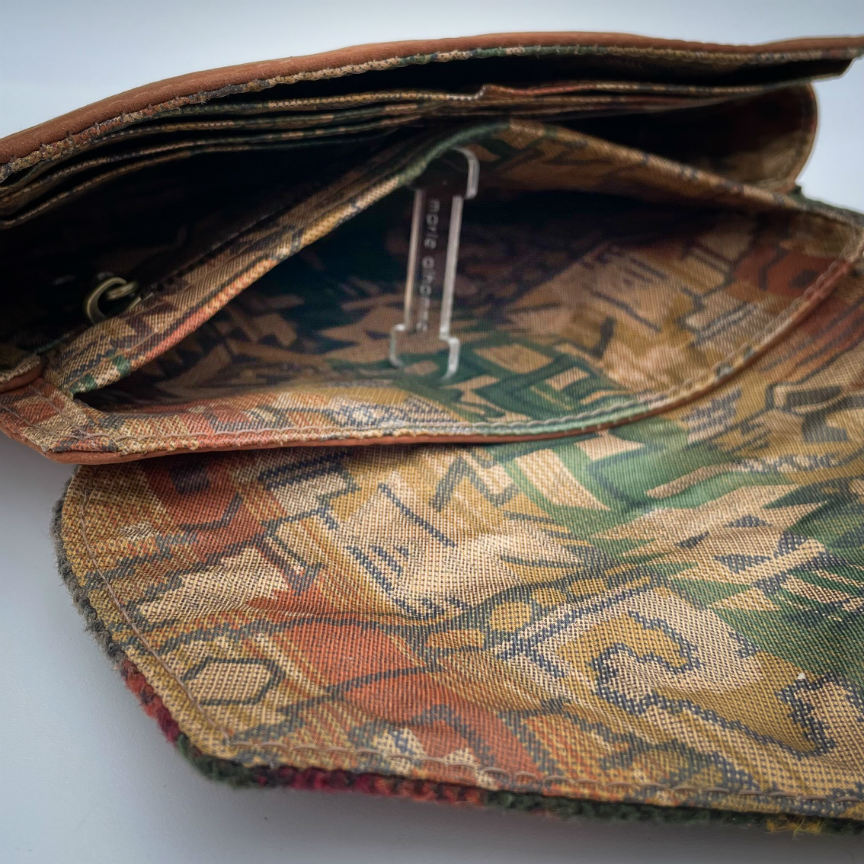A wallet made from chestnut faux suede and geometric-patterned wool fabric, with a viscose lining featuring a geometric print.