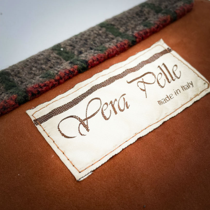 A wallet made from chestnut faux suede and geometric-patterned wool fabric, with a viscose lining featuring a geometric print.