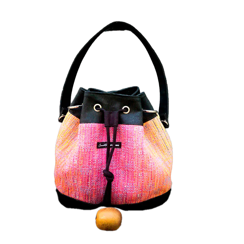 A shoulder bag made from mirror gradient woven wrap in pink to blue and black cork.