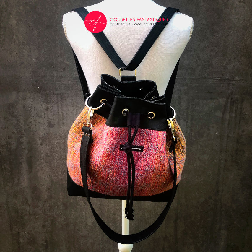 A shoulder bag made from mirror gradient woven wrap in pink to blue and black cork.
