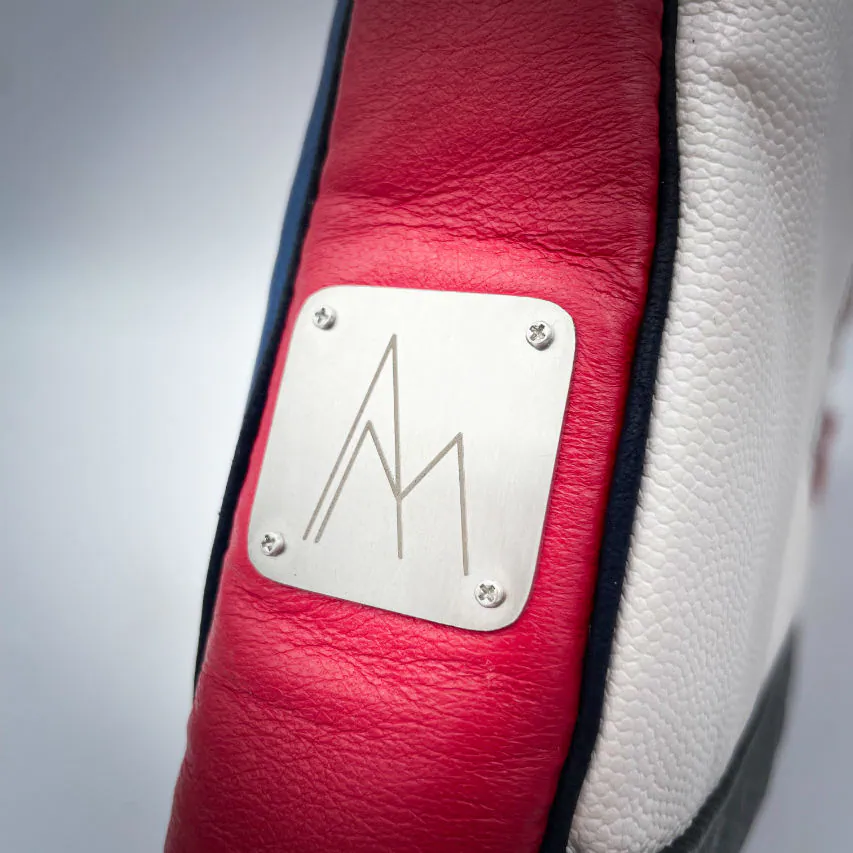 A crossbody bag made of different leathers in royal blue, deep red, bright yellow, white, and black.