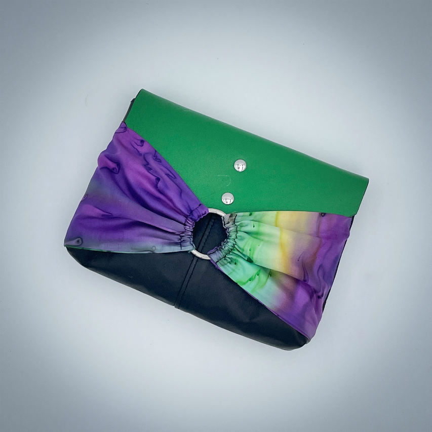 A flap clutch sewn in a yellow, green, and purple silk chiffon and paired with black, green, and yellow leathers.