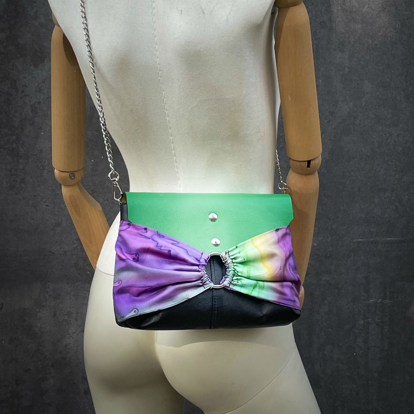 A flap clutch sewn in a yellow, green, and purple silk chiffon and paired with black, green, and yellow leathers.