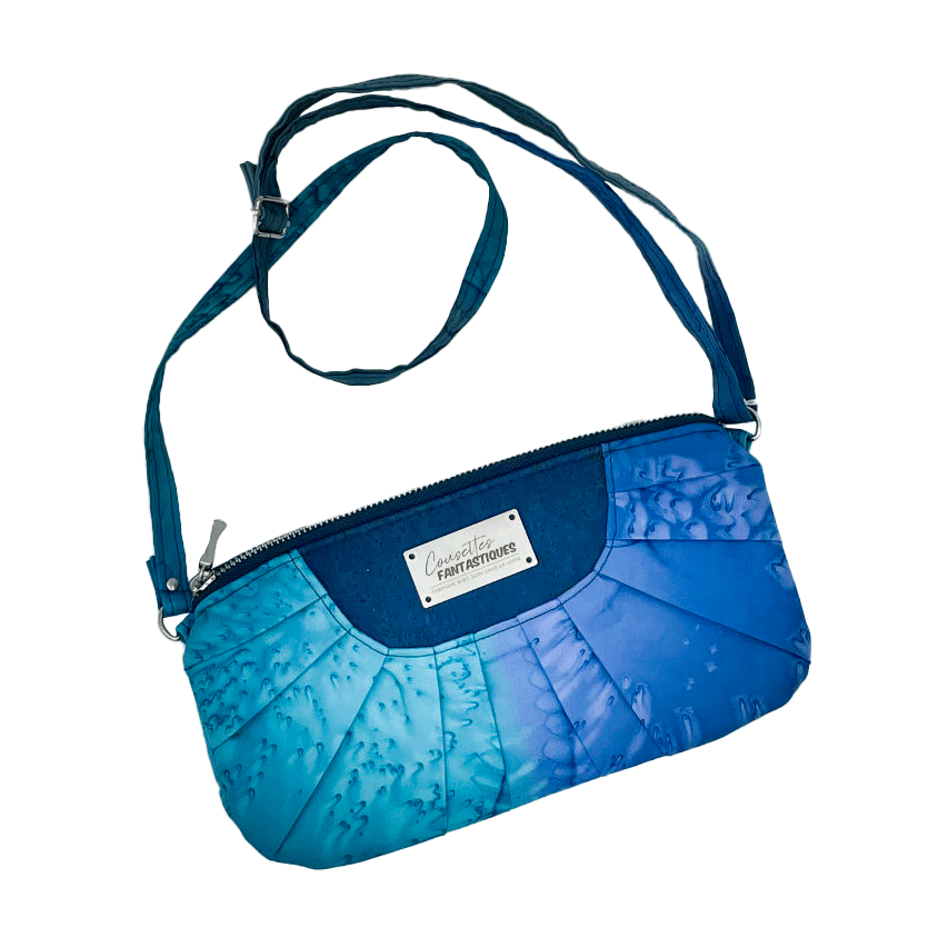 A zippered pouch sewn from a silk scarf in shades of blue, pleated and combined with royal blue cork.