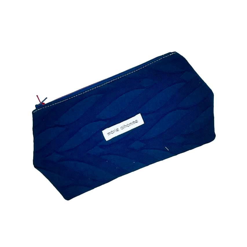 A double zippered pouch sewn from several babywearing wrap scraps (blue and red) and white faux leather.