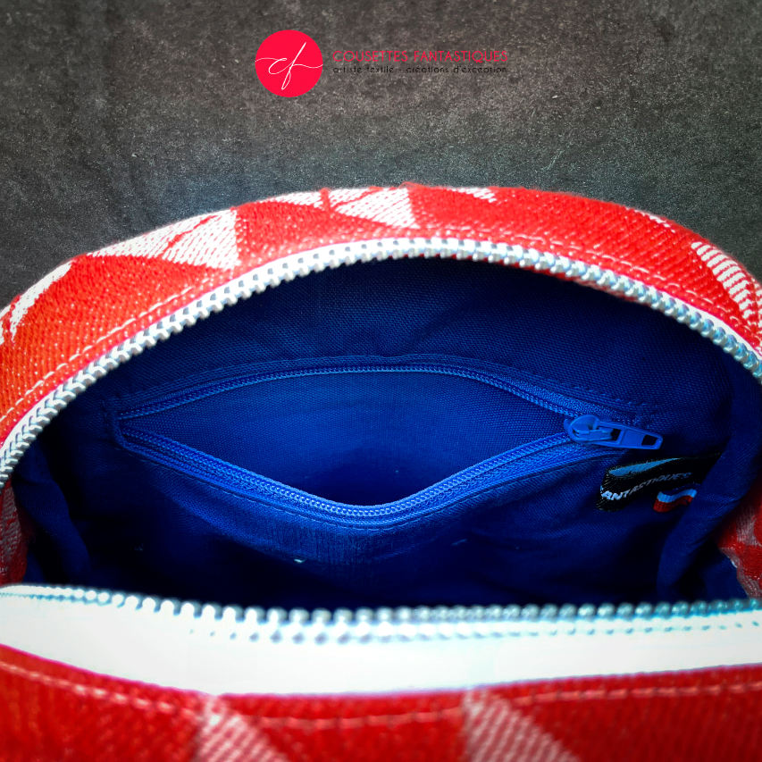 A mini handbag made of orange babywearing wrap fabric with a white geometric pattern, and blue Klein workwear fabric.