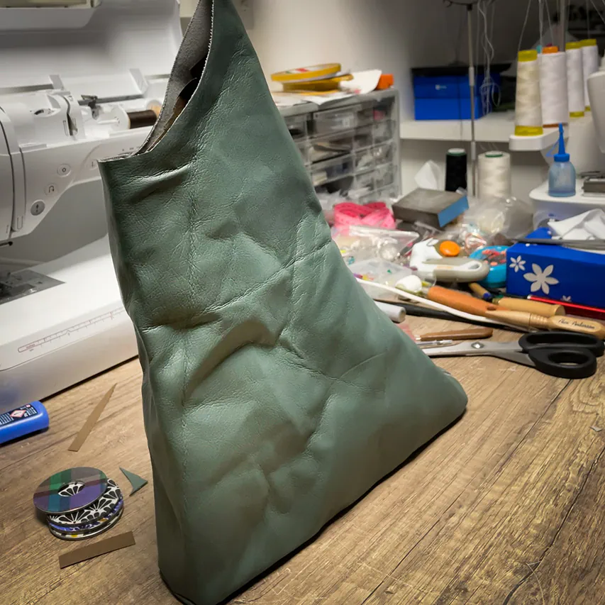 A handbag made of metallic leather with an iridescent red satin lining.