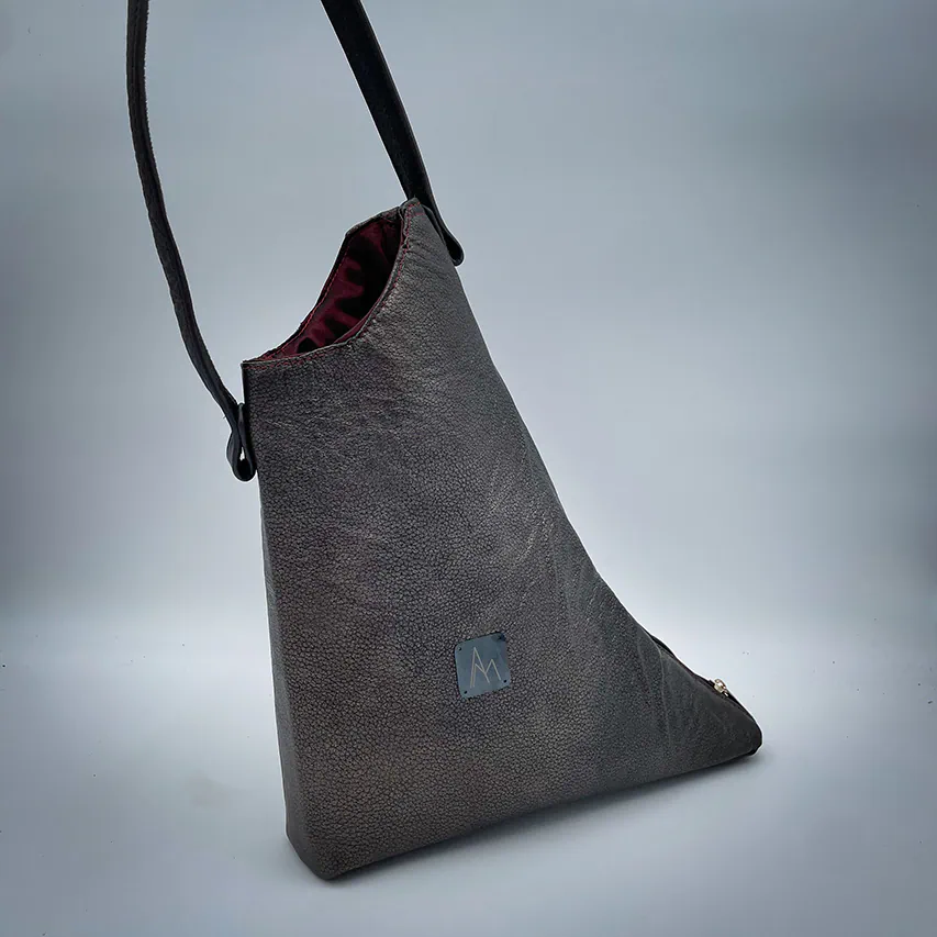 A handbag made of metallic leather with an iridescent red satin lining.
