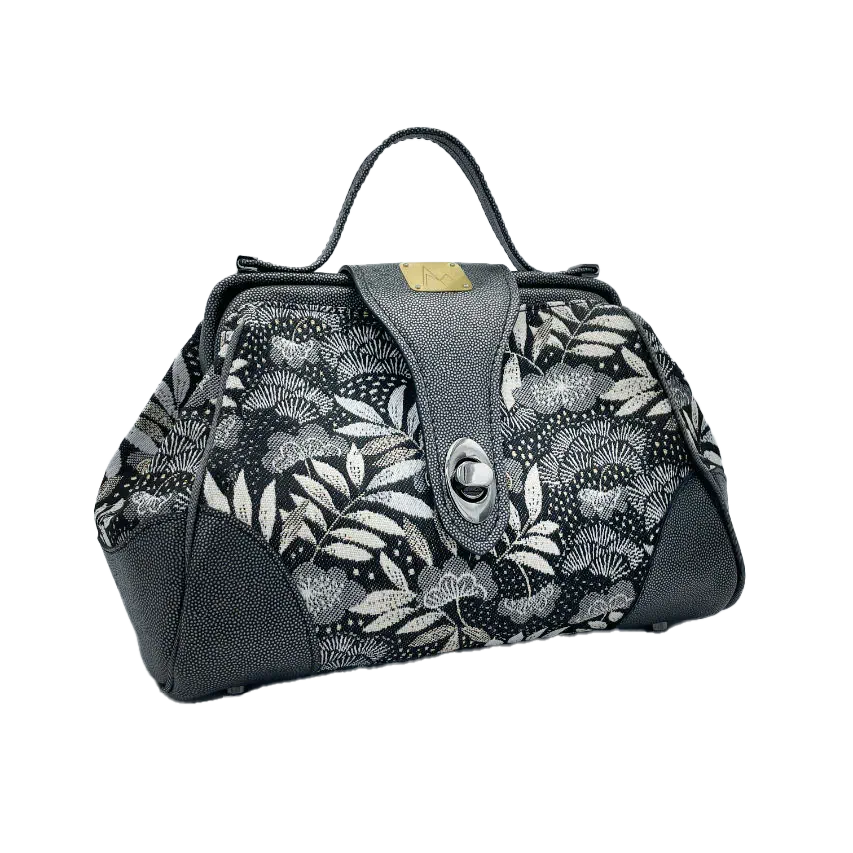 A mini handbag made of black, white, gray, and gold upholstery fabric, combined with anthracite and silver leather.