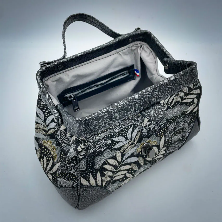 A mini handbag made of black, white, gray, and gold upholstery fabric, combined with anthracite and silver leather.