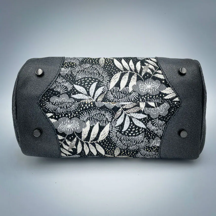 A mini handbag made of black, white, gray, and gold upholstery fabric, combined with anthracite and silver leather.