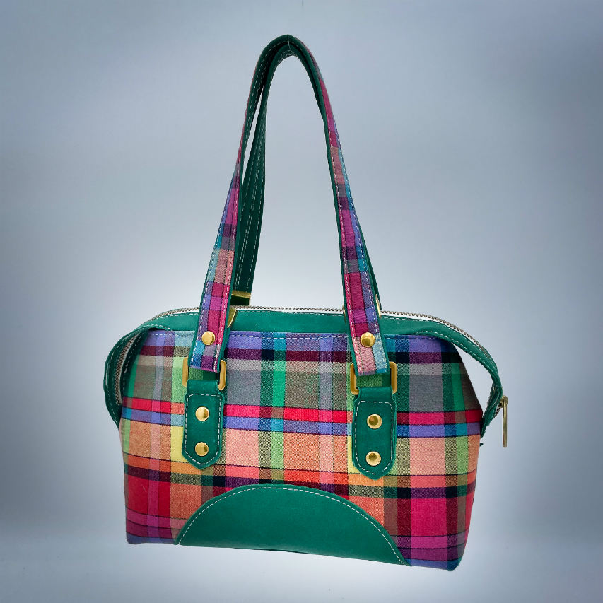 A wallet bag made of forest green leather and multicolored madras fabric.