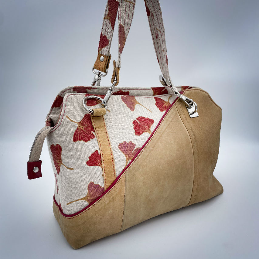 A handbag made of camel colored leather and a red Ginkgo Biloba leaves patterned polycotton canvas.
