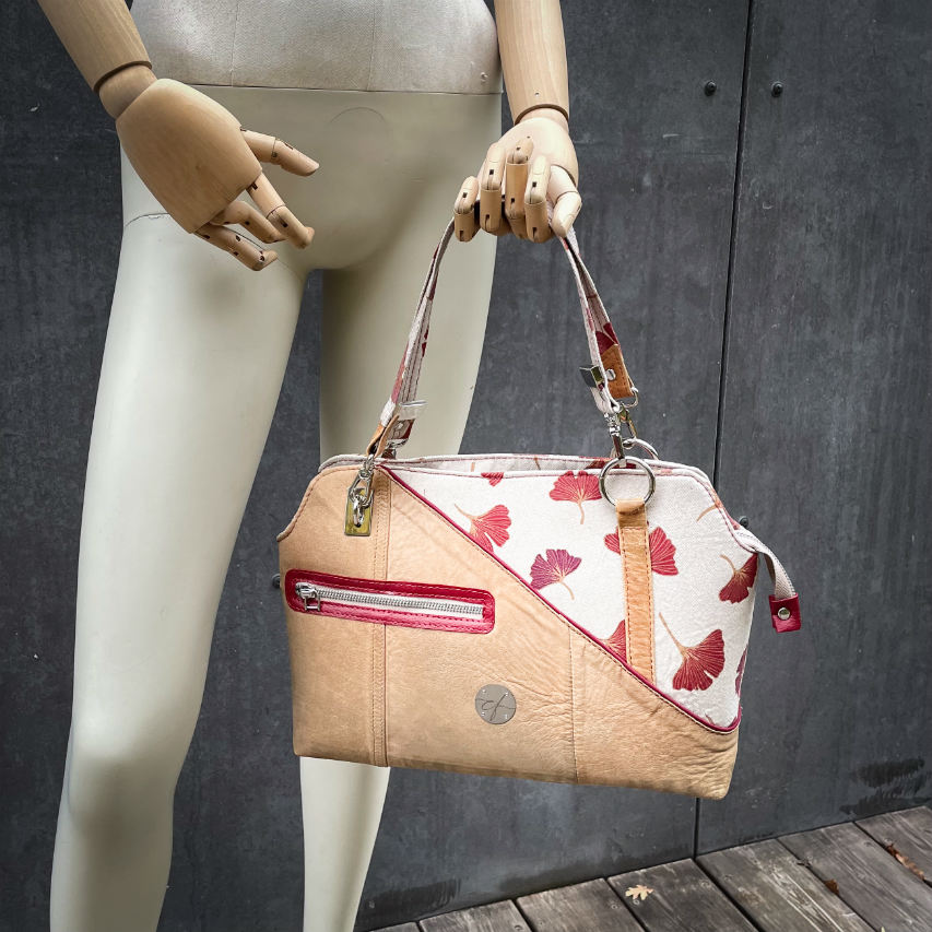 A handbag made of camel colored leather and a red Ginkgo Biloba leaves patterned polycotton canvas.