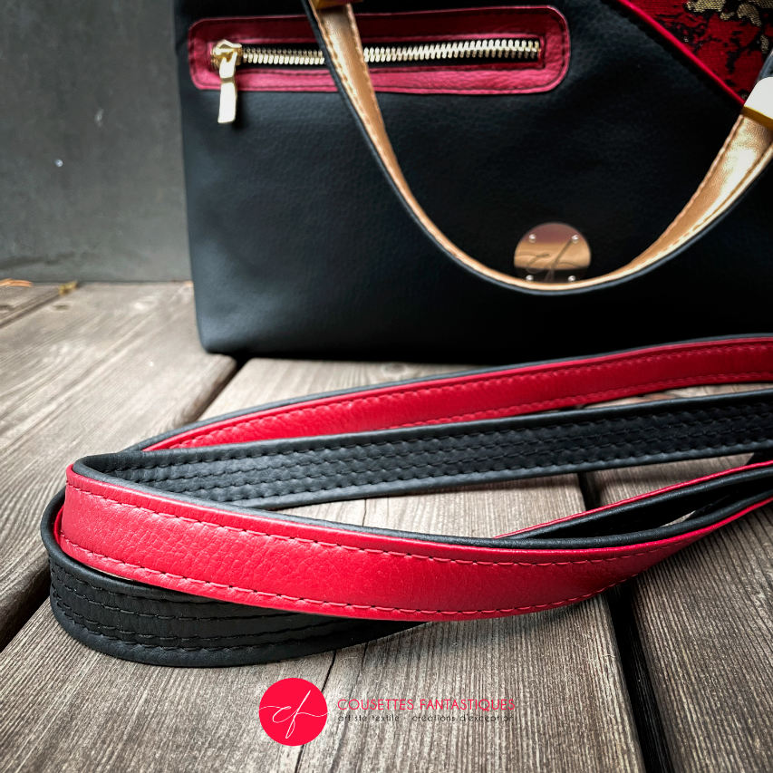 A handbag made of black, gold, and red faux leather and wrap fabric in the same tones, with a marbled pattern.