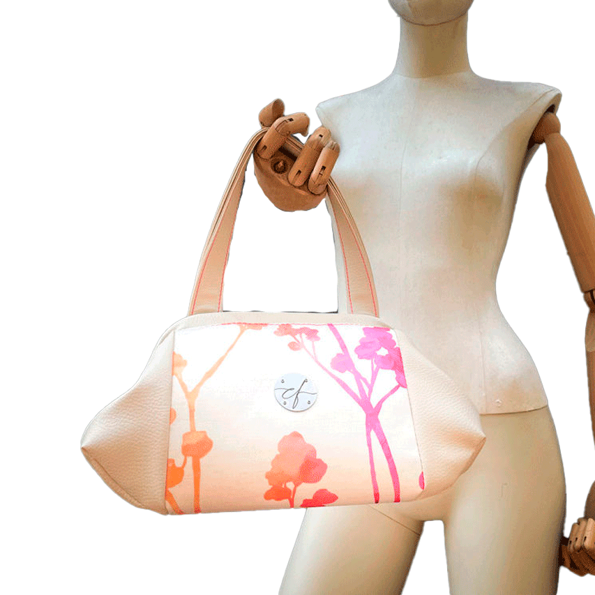 A handbag made of cream synthetic upholstery fabric and cream faux leather, featuring a gradient botanical pattern from pink to orange.
