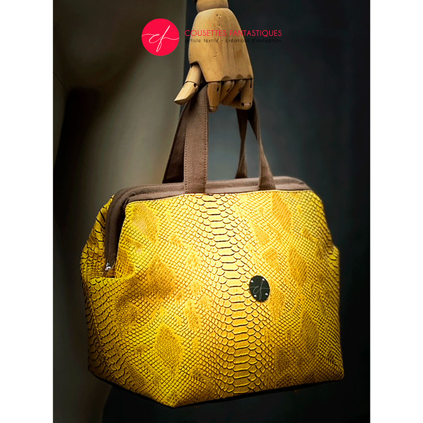 A handbag made with crocodile-textured yellow and brown synthetic leather.