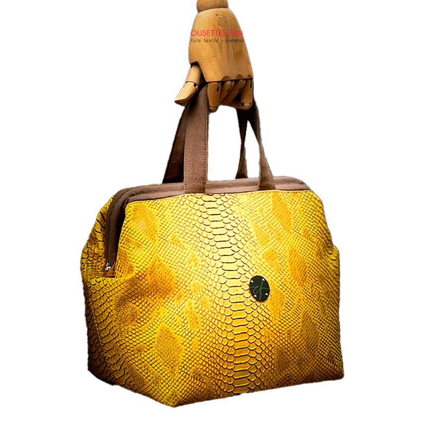 A handbag made with crocodile-textured yellow and brown synthetic leather.