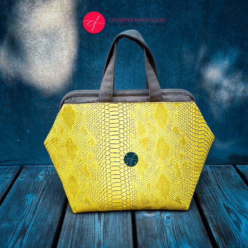 A handbag made with crocodile-textured yellow and brown synthetic leather.