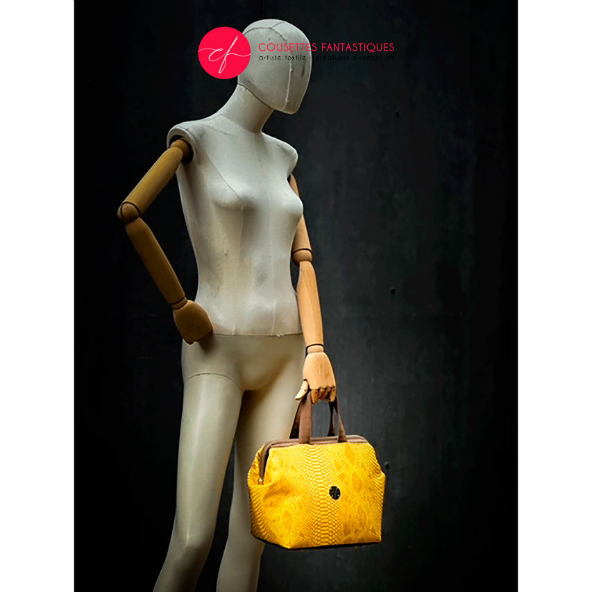 A handbag made with crocodile-textured yellow and brown synthetic leather.