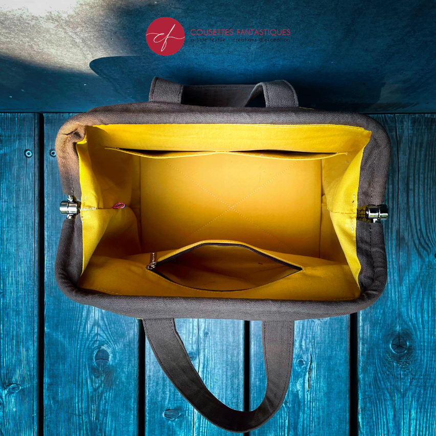 A handbag made with crocodile-textured yellow and brown synthetic leather.