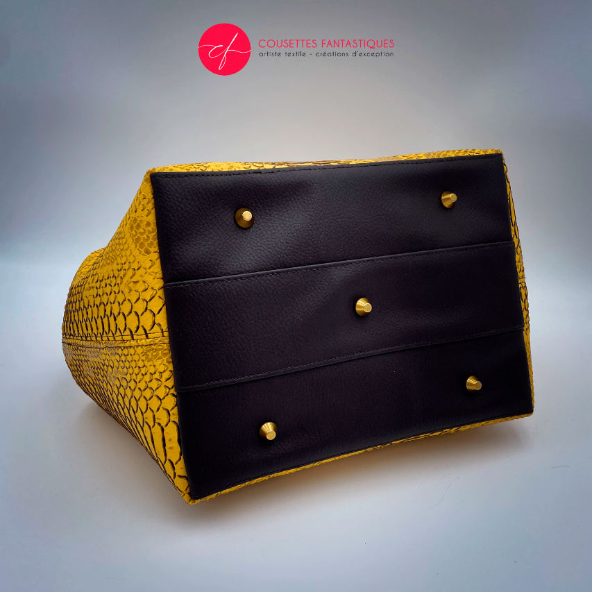 A handbag made with crocodile-textured yellow and brown synthetic leather.