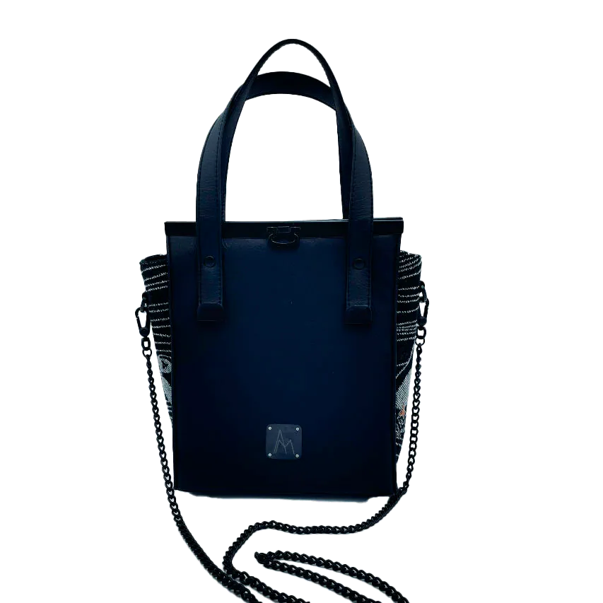 A small handbag made of babywearing wrap scraps showing puffins in stylized waves in black, white and orange tones, and black faux leather.