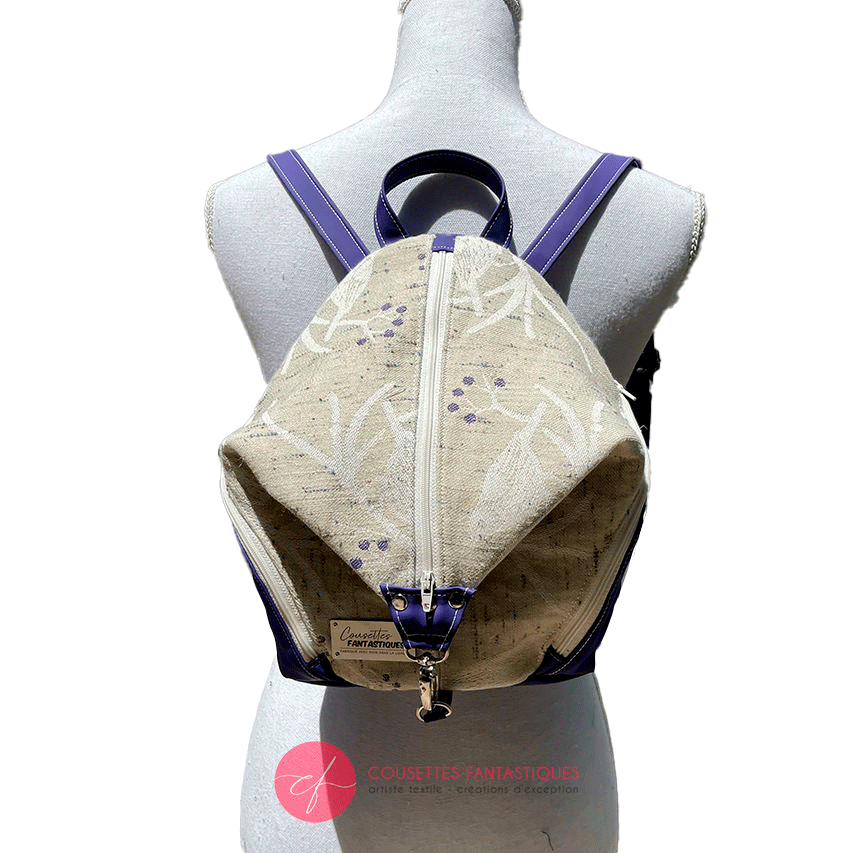 A backpack sewn in royal blue canvas and wax fabric in blue, brown-red, black, and white tones.