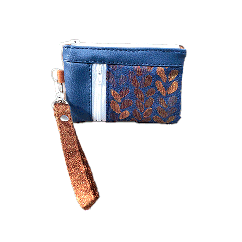 A mini zippered coin purse made up of a patchwork of different materials: royal blue faux leather, golden faux leather, shiny bronze fabric, and blue and bronze wrap fabric with a pattern of small droplets.