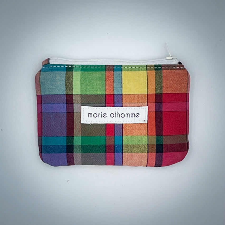 A mini zippered coin purse made from a patchwork of different materials: multicolor checkered madras and black lambskin leather.