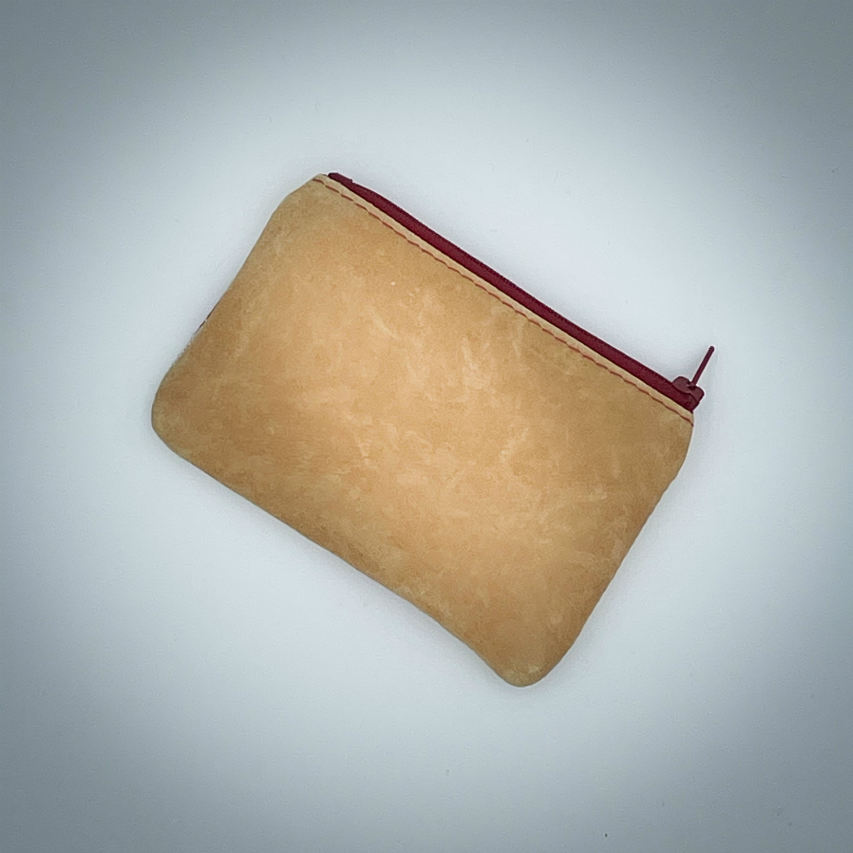 A mini zippered coin purse made of camel colored leather and a red Ginkgo Biloba leaves patterned polycotton canvas.