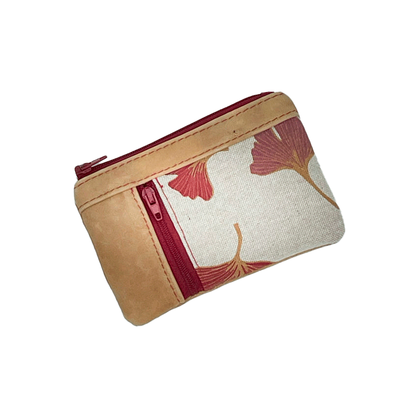 A mini zippered coin purse made of camel colored leather and a red Ginkgo Biloba leaves patterned polycotton canvas.
