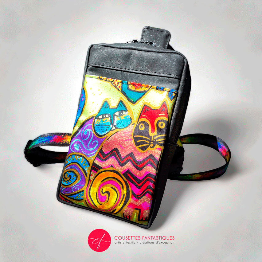 A small backpack made of matte black cork and a silk scarf with a colorful cat pattern, with a black and rainbow adjustable strap.