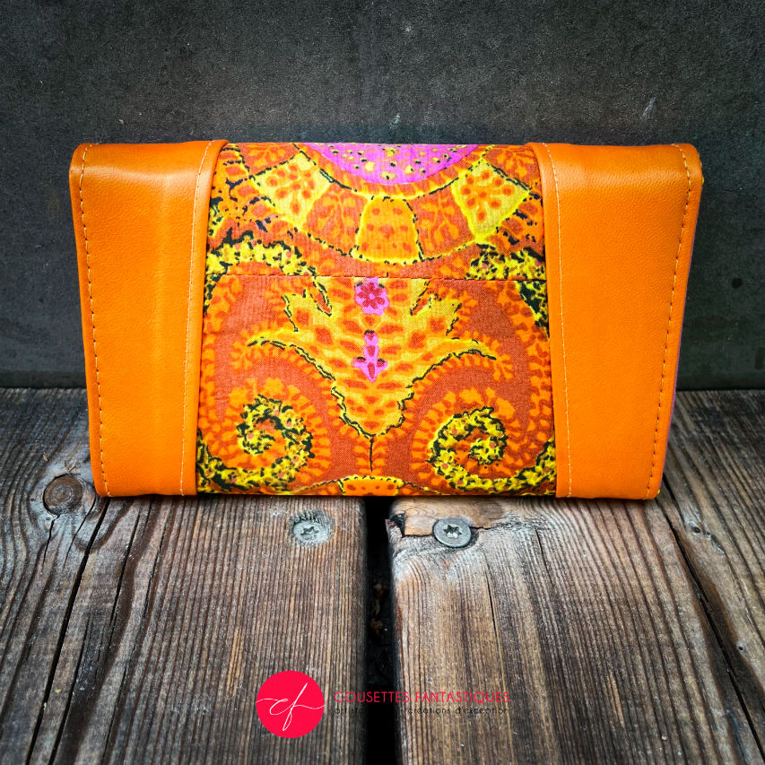 A wallet made of orange lambskin leather and vintage multicolored rayon, in shades of orange, yellow, and pink.