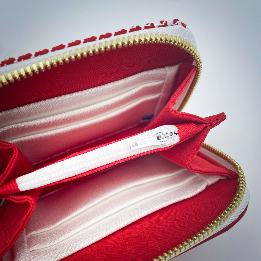 A zipped card-and-coin wallet made from red leather and a red leather printed with white houndstooth, with a red Sonia Rykiel branded lining.